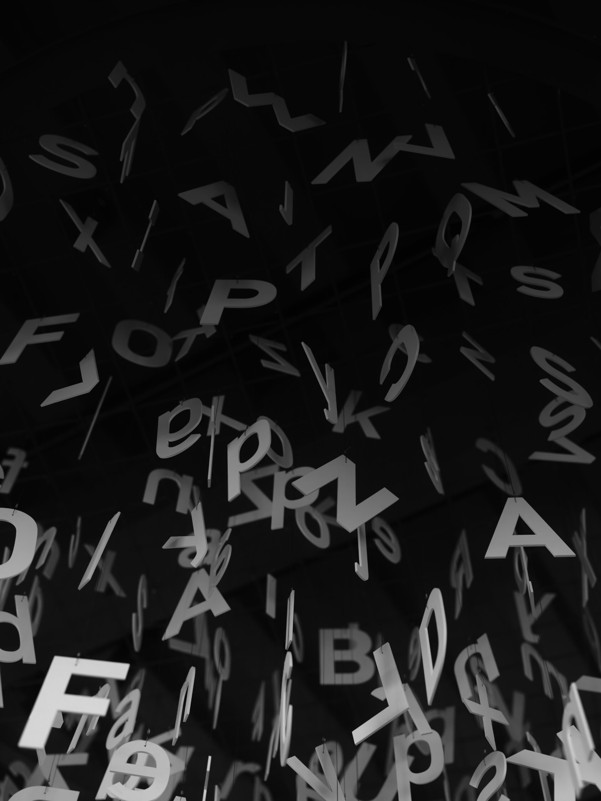 Scattered letters and typographic forms on a dark background